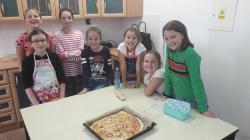 Uczniowie przygotowujący pizzę w ramach zajęć koła Akademia Młodego Kucharza