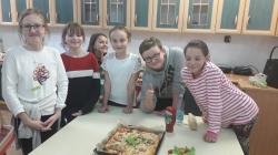 Uczniowie przygotowujący pizzę w ramach zajęć koła Akademia Młodego Kucharza