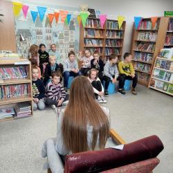 Uczniowie podczas Dnia Głośnego Czytania 2022 w bibliotece.
