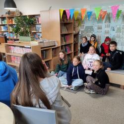 Uczniowie podczas Dnia Głośnego Czytania 2022 w bibliotece.
