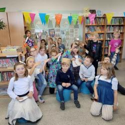 Uczniowie podczas Dnia Głośnego Czytania 2022 w bibliotece.