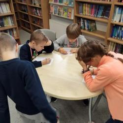 Uczniowie podczas Dnia Głośnego Czytania 2022 w bibliotece.