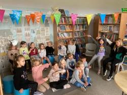 Oddział przedszkolny podczas zajęć o kotku Kubusiu w bibliotece szkolnej.