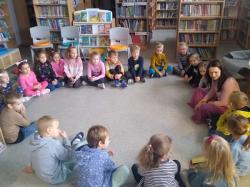 Oddział przedszkolny podczas zajęć o kotku Kubusiu w bibliotece szkolnej.